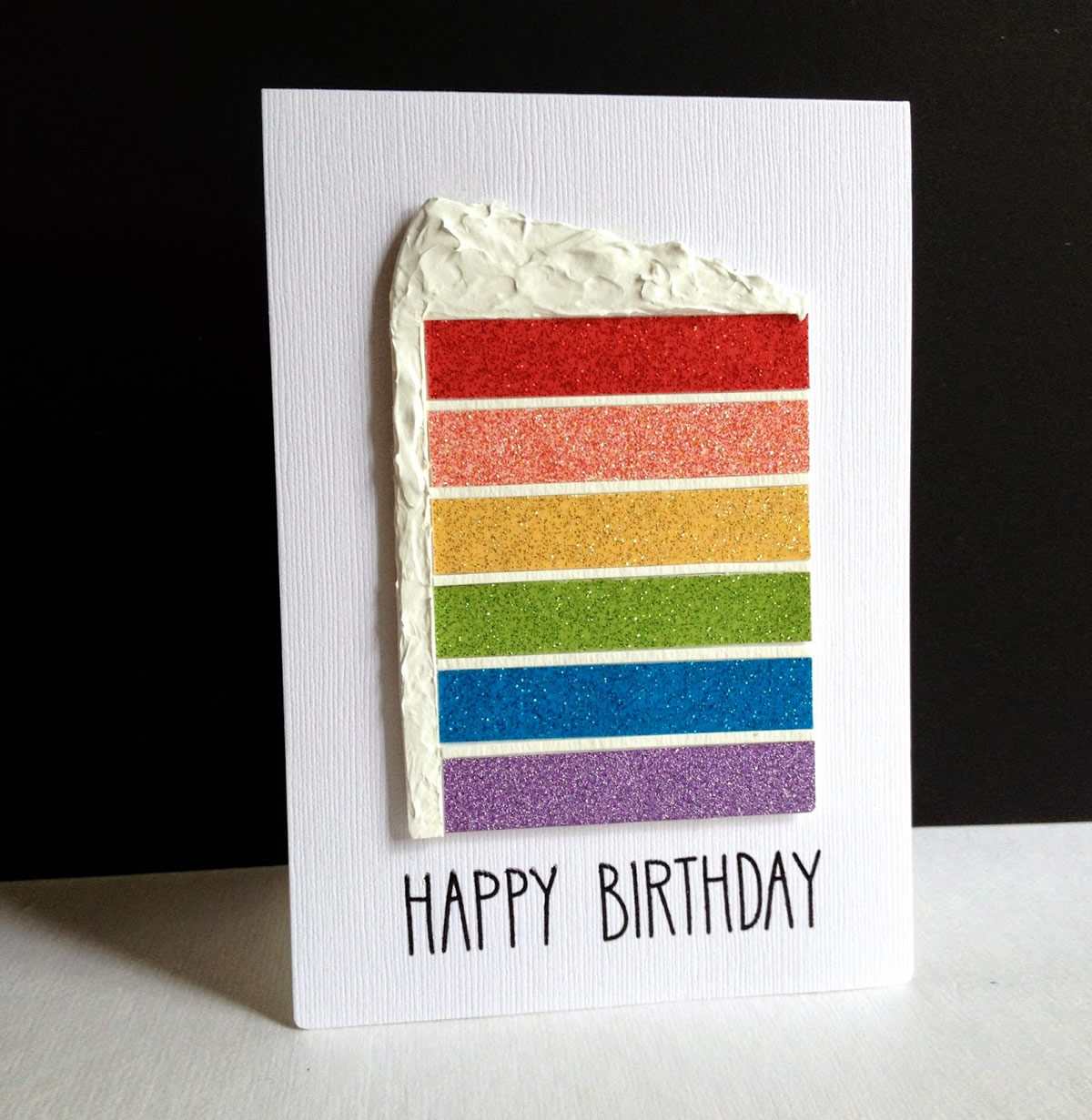 Biglietto di auguri con torta di compleanno arcobaleno